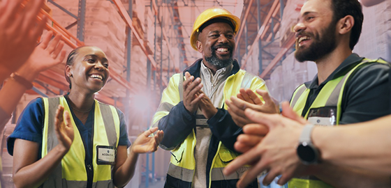 A team of safety workers celebrate an accomplishment with leadership as part of a recognition program.